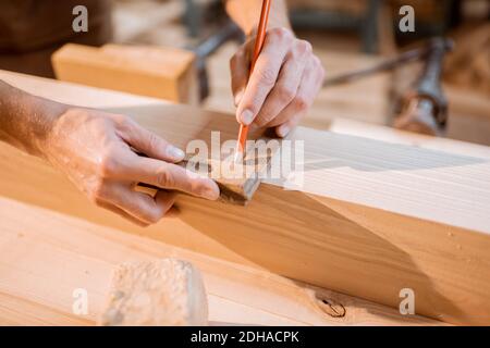 Falegname lavorazione legno, marcatura tavola con matita in officina di carpenteria, vista ravvicinata Foto Stock