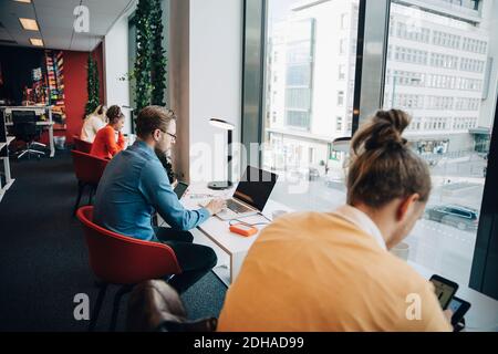 Personale aziendale multietnico che lavora alla scrivania in ufficio Foto Stock