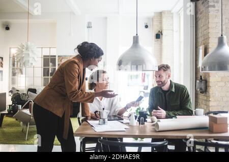 Architetti sorridenti che discutono e progettano in ufficio domestico Foto Stock