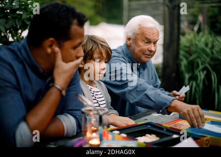 Gioco da tavolo per tutta la famiglia mentre sei seduto al tavolo cortile Foto Stock