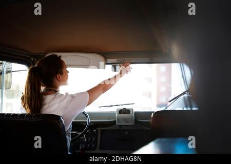 Vista posteriore dello specchietto retrovisore per la regolazione del proprietario della donna negli alimenti carrello Foto Stock