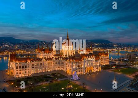 Edificio del parlamento ungherese al momento della critica. Incredibile vista aerea sull'edificio del governo ungherese con un gigantesco albero di natale Foto Stock