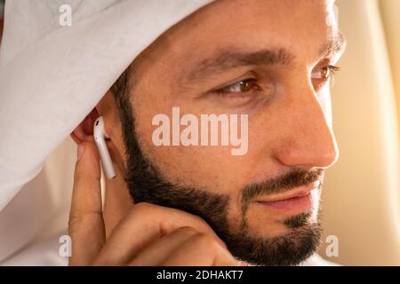 Uomo arabo che indossa kandora in stile emirates volare su esclusivo Jet privato - uomo d'affari medio-orientale con abito tradizionale vola dentro esclusiva bu Foto Stock