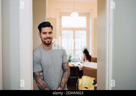 Ritratto di un uomo sorridente appoggiato sulla porta della nuova casa Foto Stock