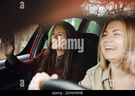 Felici le amiche che viaggiano insieme in auto Foto Stock