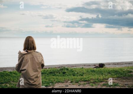 Vista posteriore della donna che guarda il mare contro il cielo Foto Stock