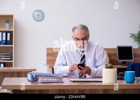 Anziano dipendente di sesso maschile che soffre di radiculite sul posto di lavoro Foto Stock