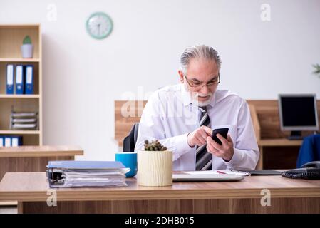 Anziano dipendente di sesso maschile che soffre di radiculite sul posto di lavoro Foto Stock