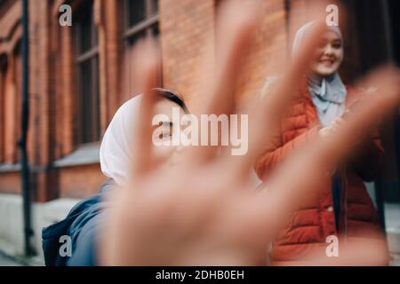 Primo piano di mano contro le amiche in città Foto Stock