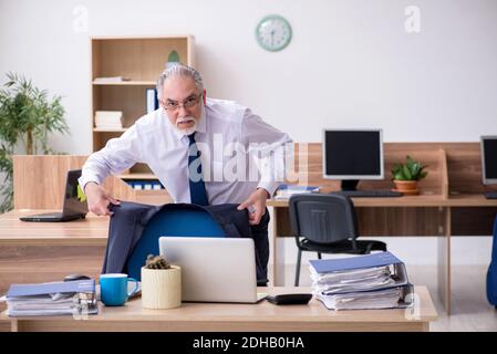 Vecchio dipendente maschile che lavora in ufficio Foto Stock