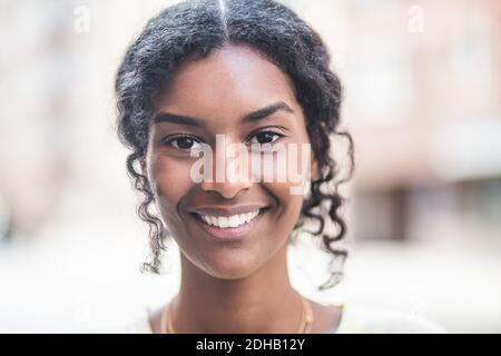 Ritratto di sorridente giovane donna in città Foto Stock