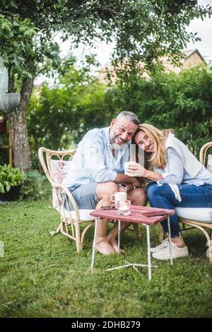 Ritratto di amare felice coppia matura che ha caffè in cortile Foto Stock