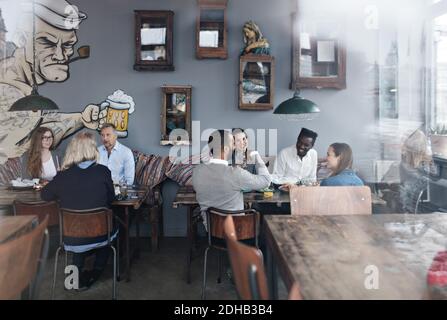La famiglia e gli amici si gustano il brunch al ristorante visto attraverso il vetro finestra Foto Stock