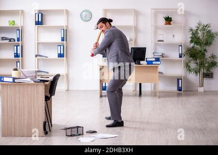 Giovane impiegato di sesso maschile e mousetrap in ufficio Foto Stock