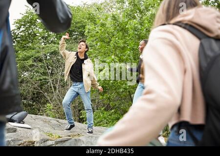 Adolescenti che guardano gli amici che ballano al parco Foto Stock