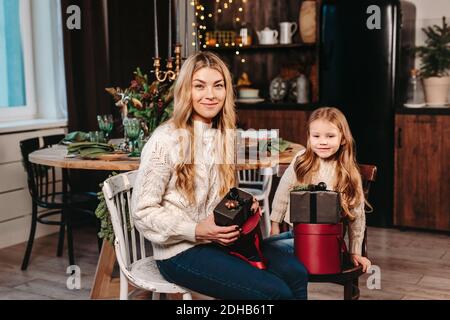 Felice madre e figlia apertura presenta sullo sfondo di Natale a. casa Foto Stock