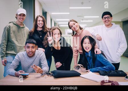 Ritratto di compagni di classe adolescenti che fanno i volti alla scrivania in classe Foto Stock