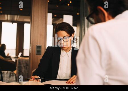 Media adulta donna avvocato discutere di lavoro con il cliente al tavolo in ufficio Foto Stock