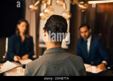 Vista posteriore di avvocato femminile con colleghi in riunione a. ufficio legale Foto Stock