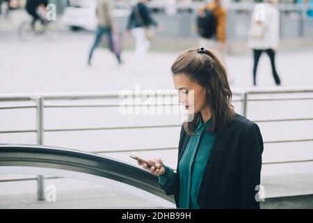 Donna d'affari sicura che usa lo smartphone in città Foto Stock