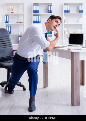 Giovane imprenditore facendo sport stretching al lavoro Foto Stock