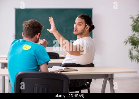 Due alunni maschi in concetto di bullismo in classe Foto Stock