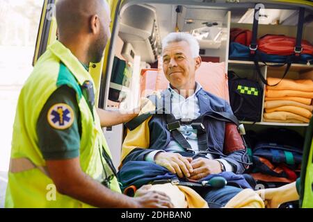 Paziente di consolazione paramedica maschile maturo in ambulanza Foto Stock