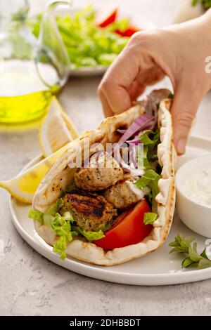 Souvlaki di pollo con verdure fresche su un pane piatto Foto Stock