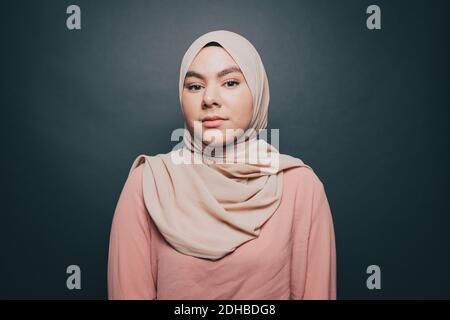 Ritratto di giovane donna sicura che indossa hijab su sfondo grigio Foto Stock