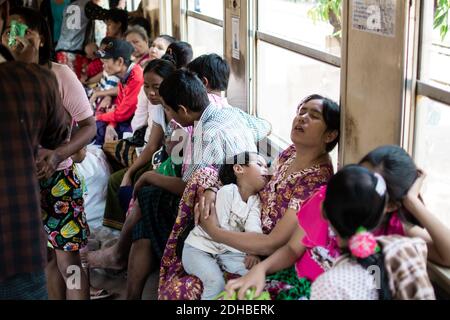 Yangon, Myanmar - 31 dicembre 2019: La vita quotidiana impegnata viaggiando sul treno circolare mentre comprando e vendendo cibo o dormendo Foto Stock