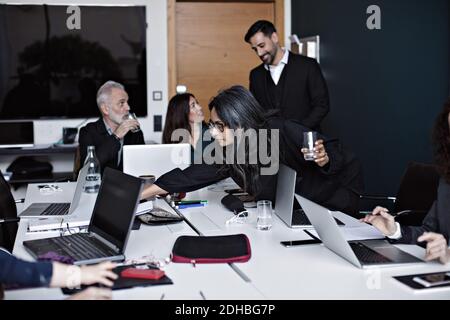 Gli uomini d'affari che lavorano al tavolo da conferenza nella sala riunioni presso ufficio Foto Stock