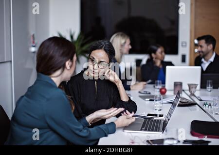 Uomini d'affari che lavorano al tavolo da conferenza nella sala riunioni Foto Stock