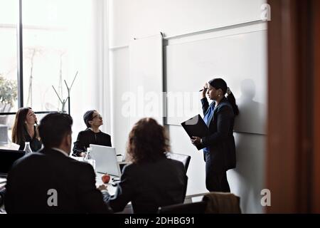 Donna d'affari che dà la presentazione ai colleghi in riunione di ufficio Foto Stock