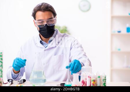 Giovane chimico maschile nel concetto di sintesi di farmaci Foto Stock