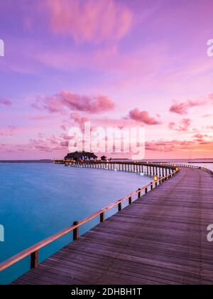 Tramonto sull'isola delle Maldive, lussuose ville d'acqua bungalow resort molo in legno. Bella cielo nuvole e Sunrise spiaggia sfondo vacanza estiva Foto Stock