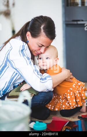 Designer di moda multi-tasking che ha abbracciato la figlia amorevole a casa Foto Stock