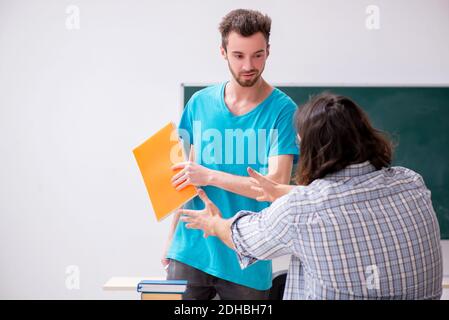 Due alunni maschi in concetto di bullismo in classe Foto Stock