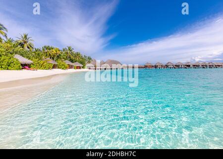 Spiaggia tropicale con bungalows acquatici sulle Maldive. Splendida costa, vista mare con lussuose ville sull'acqua e bungalow. Splendida spiaggia soleggiata Foto Stock