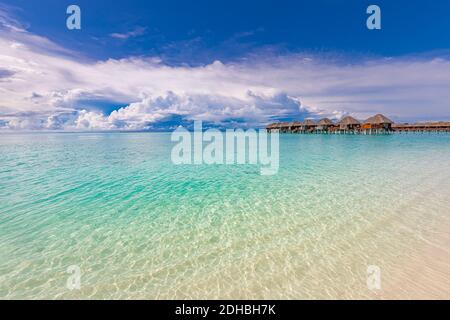 Spiaggia tropicale con bungalows acquatici sulle Maldive. Splendida costa, vista mare con lussuose ville sull'acqua e bungalow. Splendida spiaggia soleggiata Foto Stock