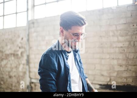 Uomo d'affari sorridente con bearded che indossa casual elegante mentre si lavora in ESSO ditta Foto Stock