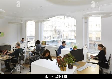 Elevato angolo di visione del business persone che lavorano alla scrivania in ufficio Foto Stock