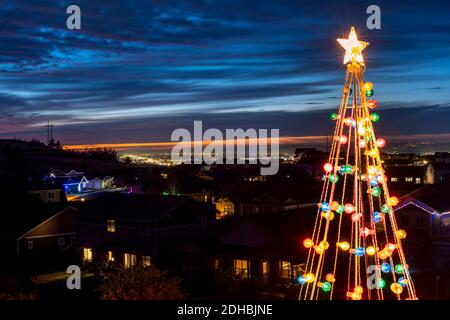 Un albero illuminato artificiale di Natale con un illuminato Città e valle in Spokane Valley Washington USA Foto Stock