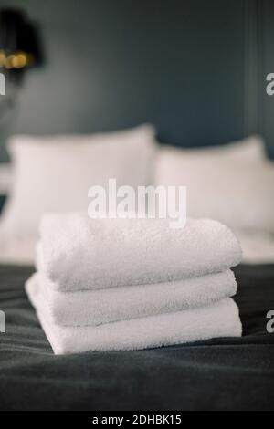 Una pila di asciugamani sul letto dell'hotel Foto Stock