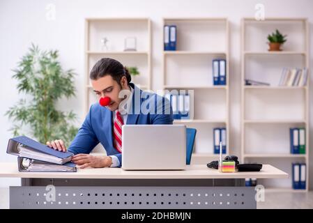 Divertente impiegato clown che lavora in ufficio Foto Stock