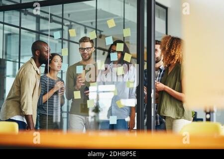 Giovani uomini e donne inventivi che hanno una discussione produttiva Foto Stock