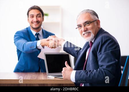 Giovane candidato maschile incontro con il vecchio reclutatore Foto Stock