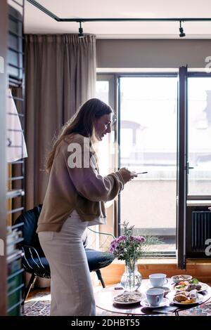 Donna che scatta una foto della colazione in camera d'albergo Foto Stock