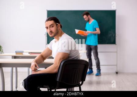 Due alunni maschi in concetto di bullismo in classe Foto Stock