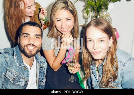 Ritratto di giovani amici multietnici sorridenti che si divertono a fare festa in appartamento Foto Stock