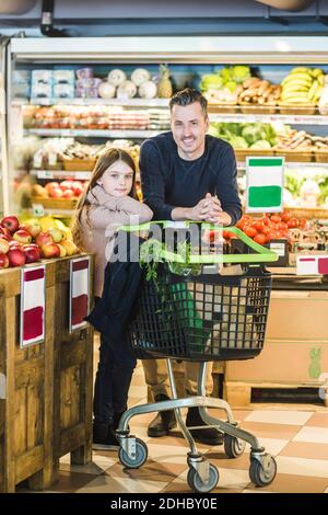 Ritratto a lunghezza intera del padre e della figlia che acquista la drogheria dentro supermercato Foto Stock